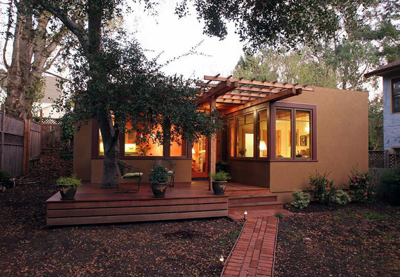 Exterior of 540 square foot home in the rear garden of a Berkeley residence, showing deck with oak tree and trellis.