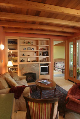 Living room with fireplace and integral shelving unit.  The fireplace acts as the heater for the entire home.