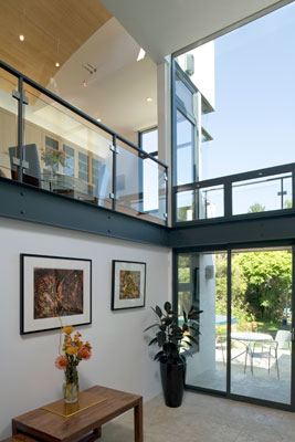 Double height atrium with floor to ceiling glass looking onto rear garden.