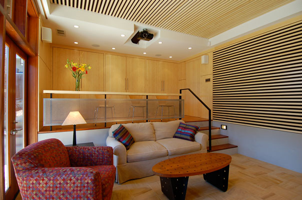 Home theater, looking at upper level and storage when closed.  This storage wall houses a media center, game cabinet and wet bar.  Custom Bamboo paneling and acoustic baffles complement India Teak tiles and cherry flooring.