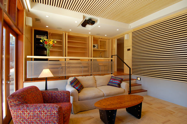 Home theater, looking at upper level and storage when open.  This storage wall houses a media center, game cabinet and wet bar.  Custom Bamboo paneling and acoustic baffles complement India Teak tiles and cherry flooring.