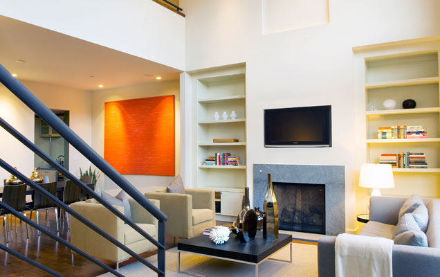 An open floor plan connects the dining and living spaces, while a mezannine level overlooks the double height space.