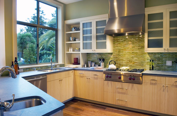 Large windows and natural materials keep the kitchen well lit and comfortable.  Custom bamboo cabinets and glass panel doors create a warm environment.